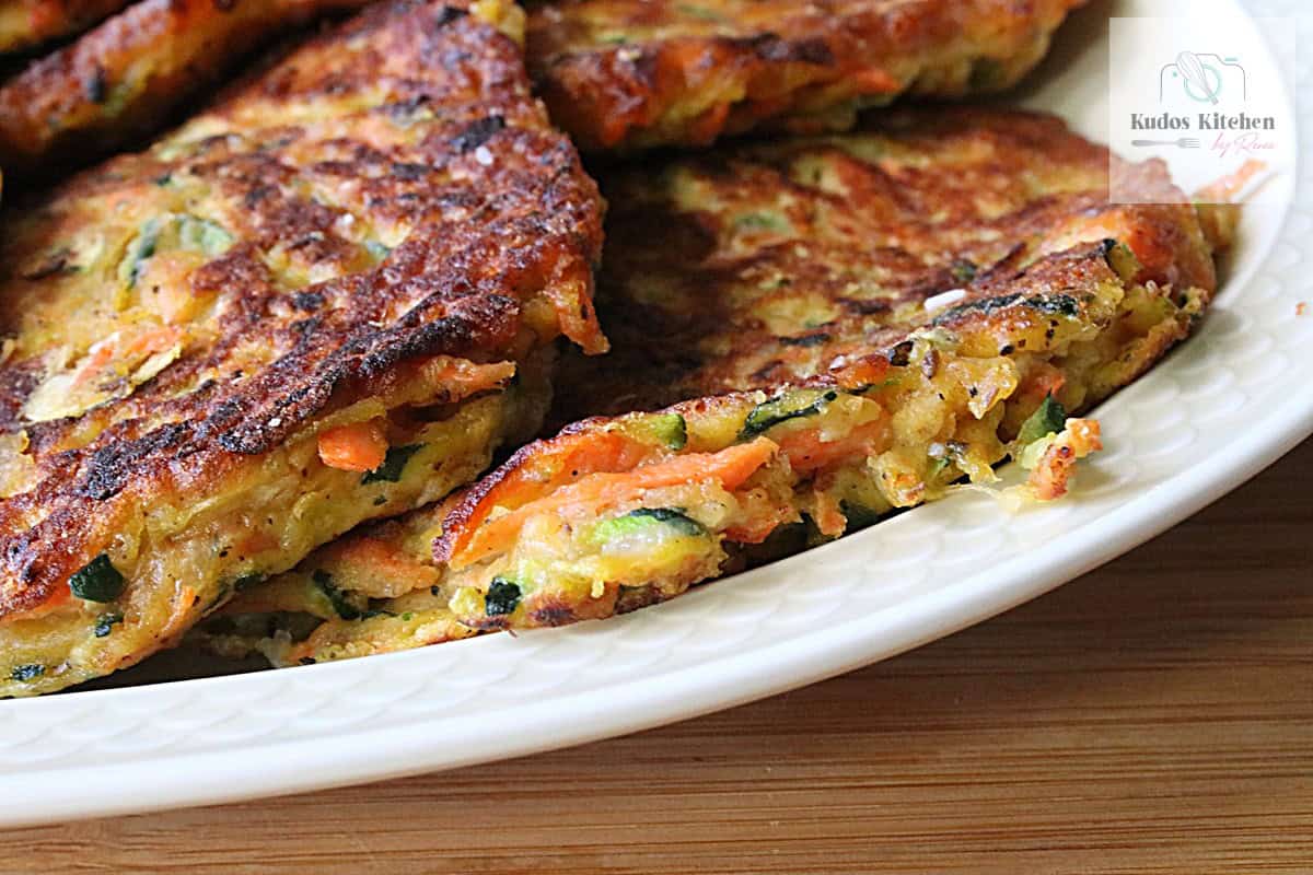 Crispy and golden brown zucchini carrot fritters on a platter.