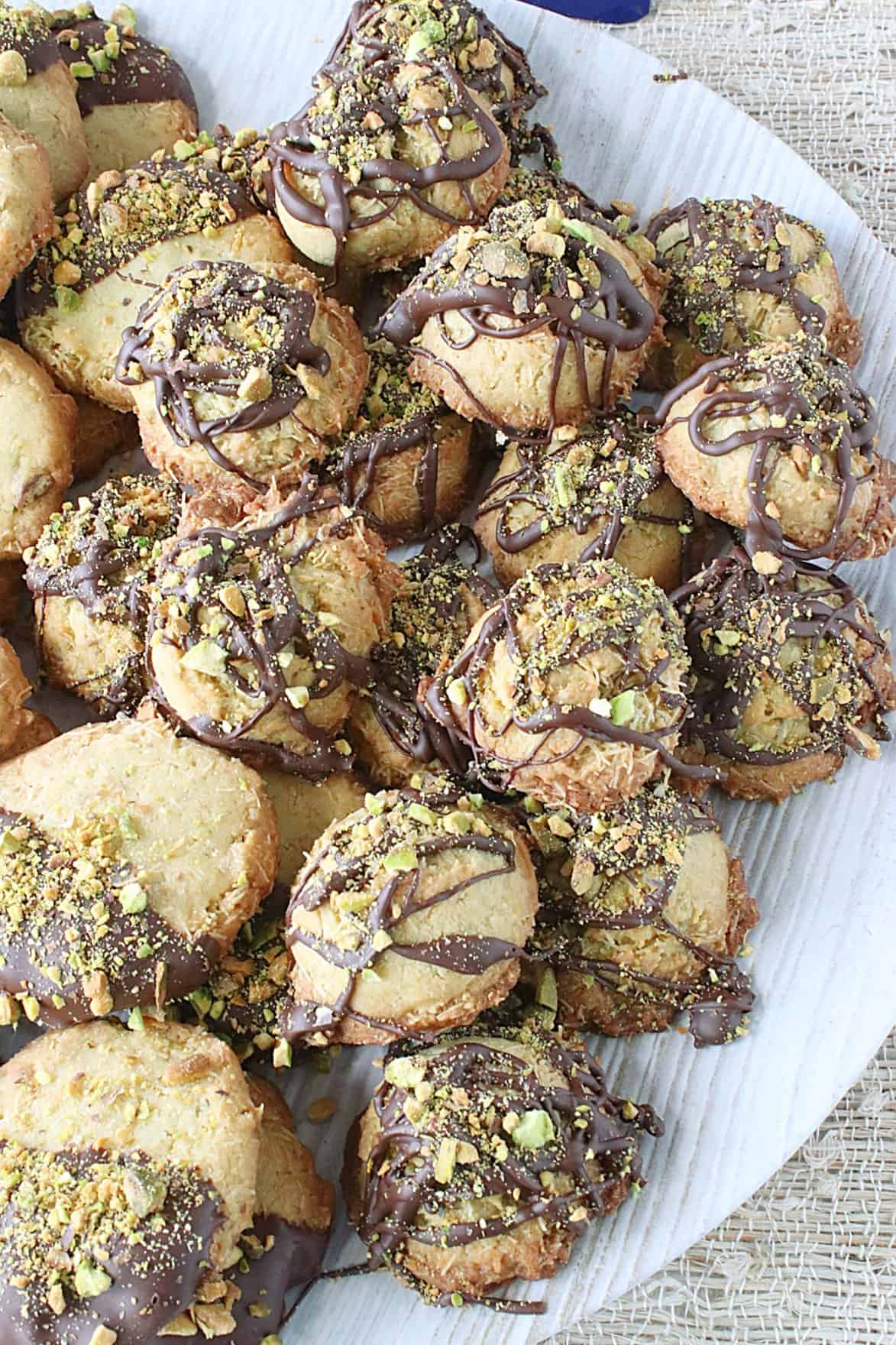 Dubai chocolate bar cookies with melted chocolate and chopped pistachios on a platter.