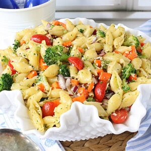 A fluted white bowl filled with Oil and Vinegar Veggie Pasta Salad.