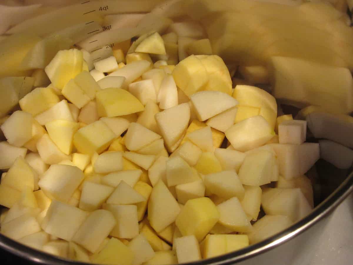 A stainless pot filled with chopped apples and pears.