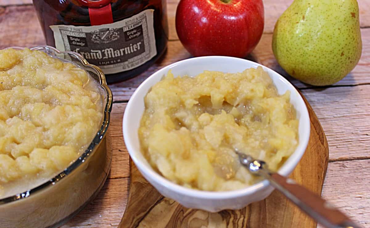 A white bowl filled with apple and pear sauce with a spoon.