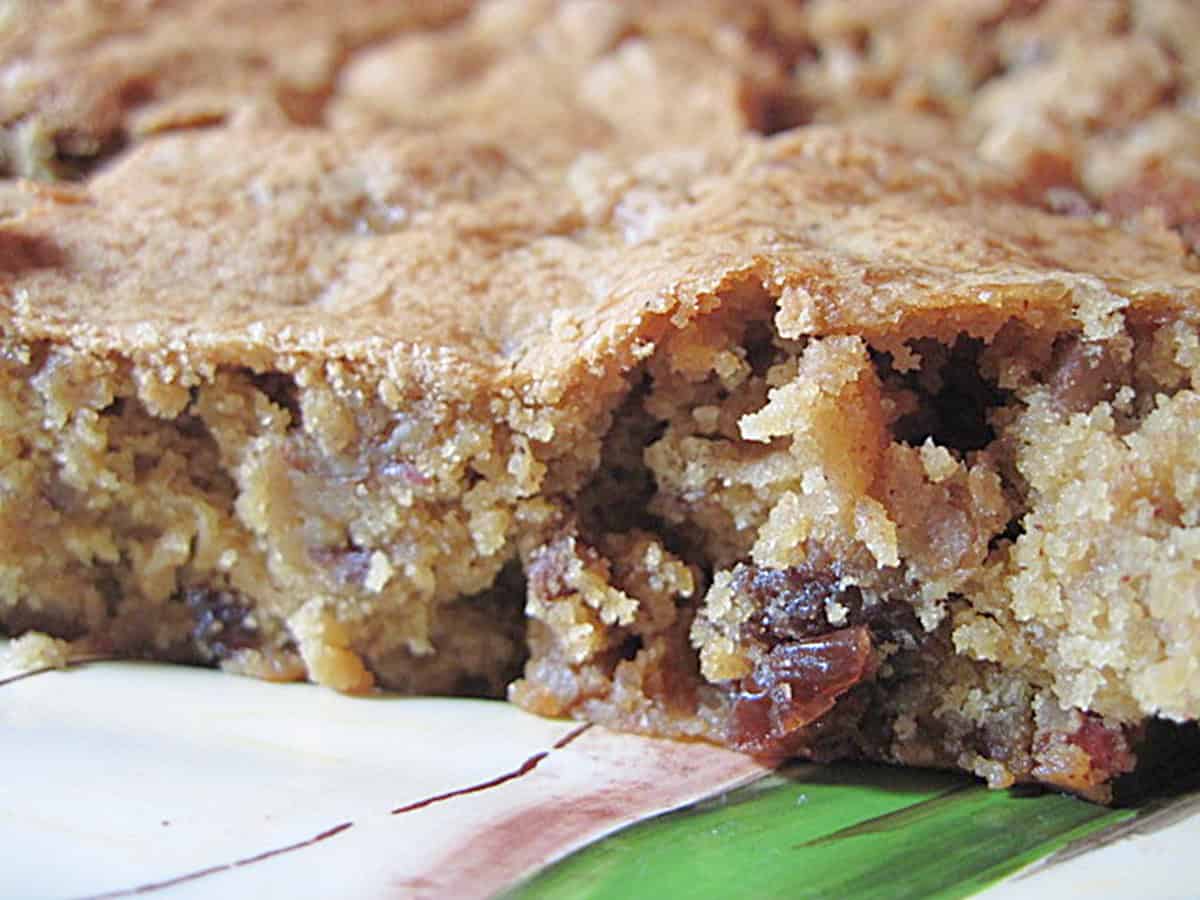 Apples and raising showing in a slice of an apple raisin cookie bar.