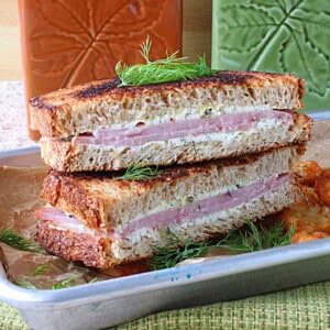 A delicious grilled ham and cream cheese sandwich on a small silver baking sheet.