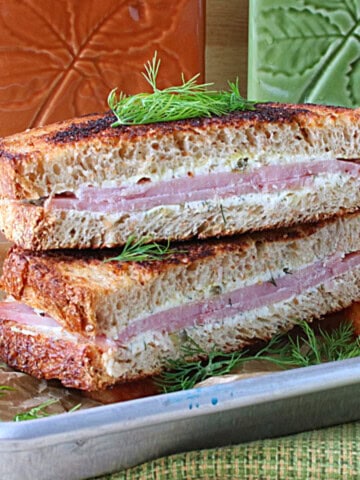 A delicious grilled ham and cream cheese sandwich on a small silver baking sheet.
