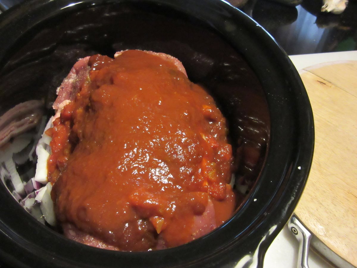 Salsa, onions, and pork tenderloin in a slow cooker.