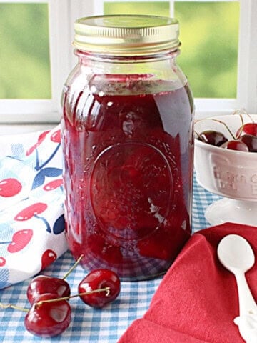 Cherry Pie filling in a jar by a window.