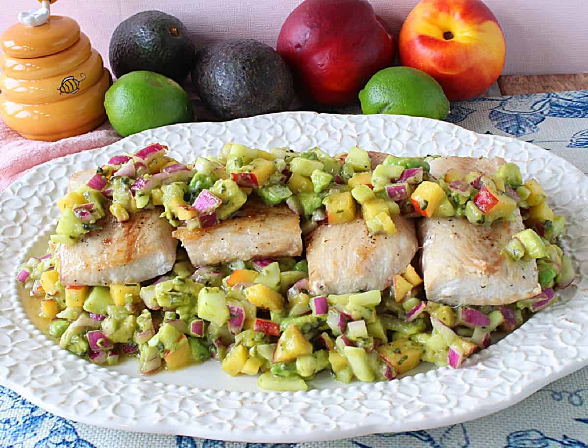 Healthy Seared Mahi Mahi with Nectarine-Avocado Salsa is the perfect summertime meal that will help you beat the heat, and keep you feeling light on your toes. - www.kudoskitchenbyrenee.com A pretty platter of four seared mahi mahi filets surrounded by nectarine and avocado salsa.