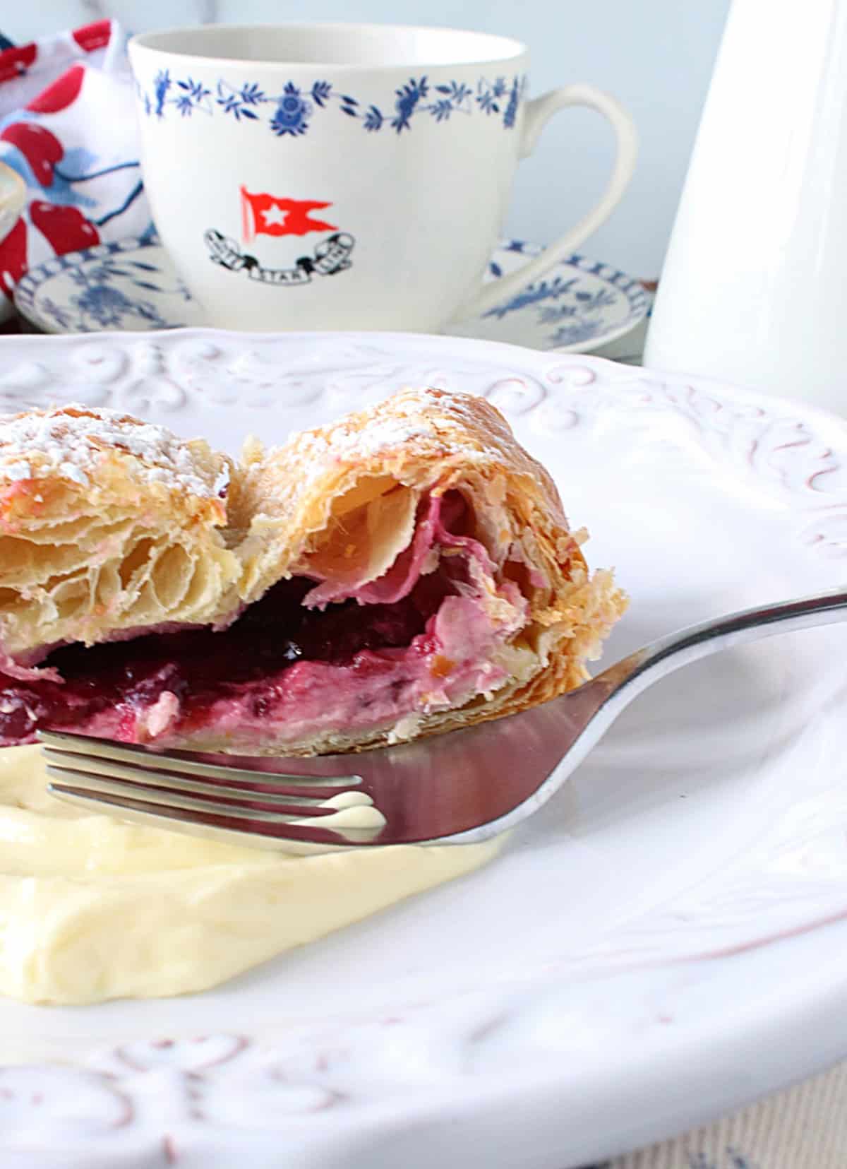 Flaky layers of puff pastry surrounding a cherry and cheesecake filling.