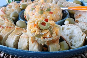 A blue cheese server with bread slices and a cheeseball in the center.