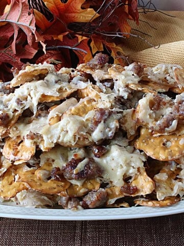 A platter piled high with German Pretzel Chip Nachos and bratwurst.