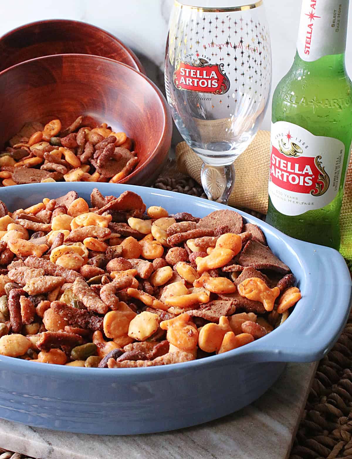 An oval blue bowl filled with a crunchy homemade snack mix.