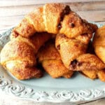 A pretty blue platter full of chocolate cinnamon croissants.