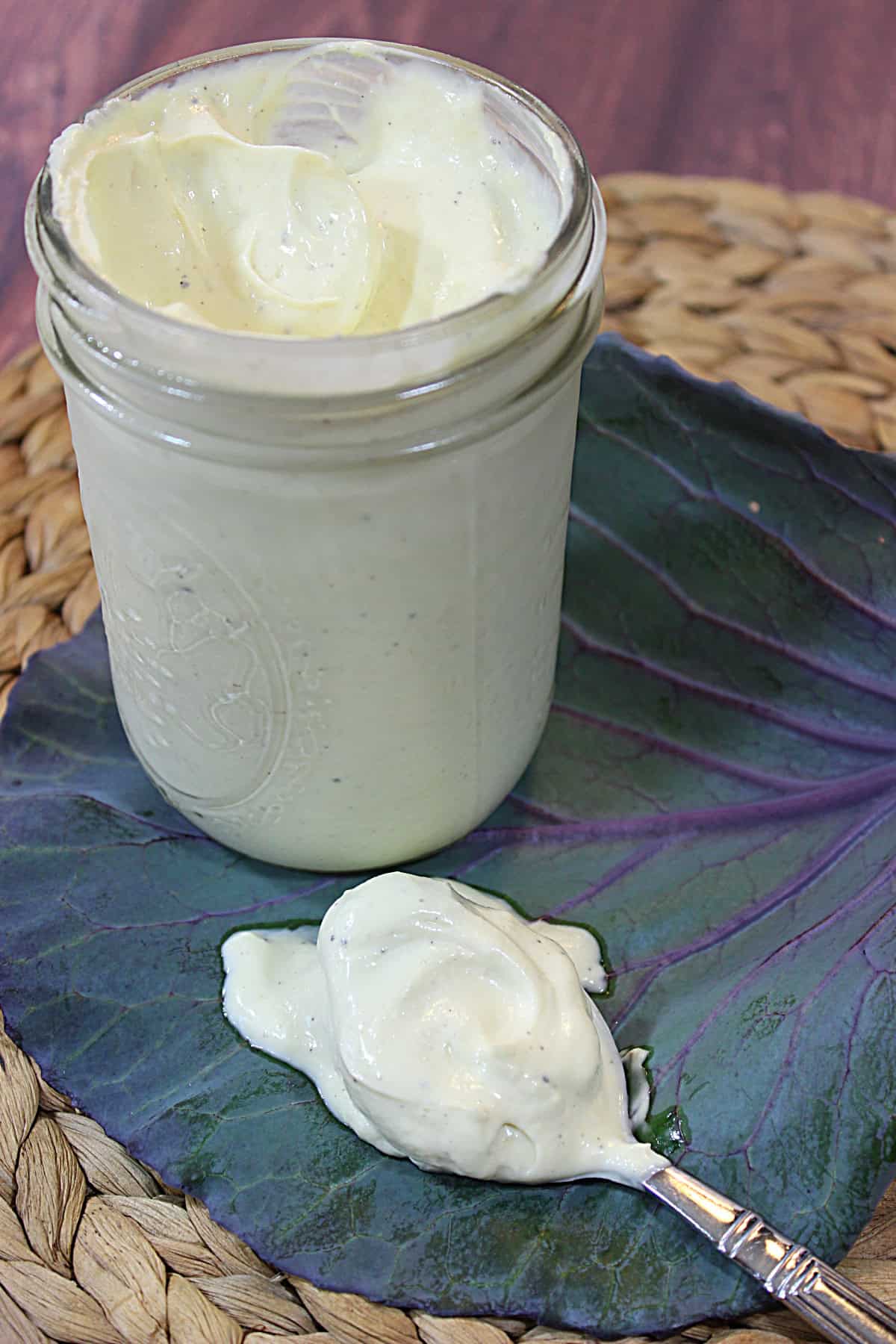 A mason jar and a spoon full of Avocado Oil Mayonnaise.