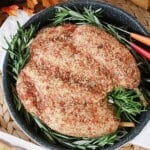 A fun and realistic looking turkey cheeseball for Thanksgiving with fresh rosemary in a roasting pan.