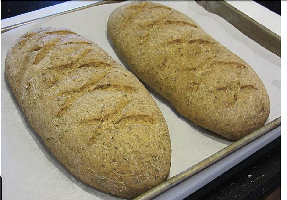 Two loaves of rye bread out of the oven after baking.