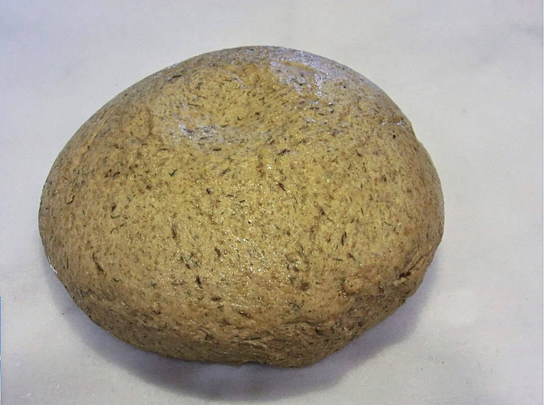 A round risen ball of homemade rye dough.