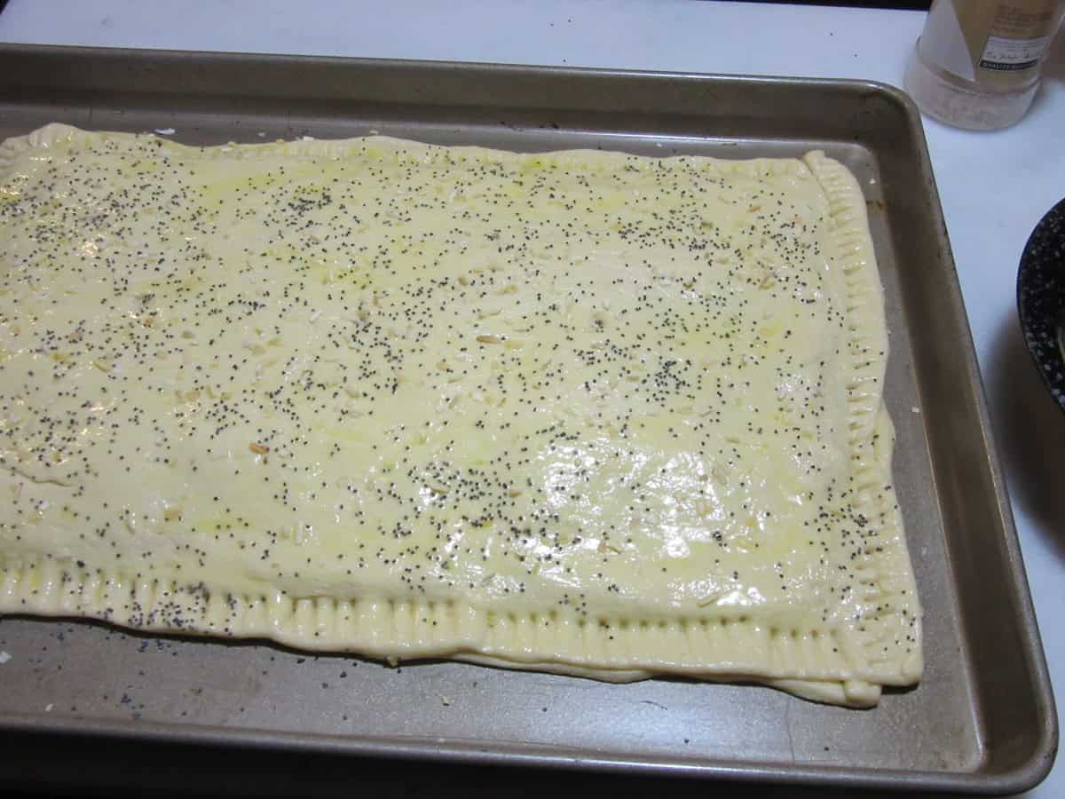 Crimped edges of crescent roll dough on a baking sheet.