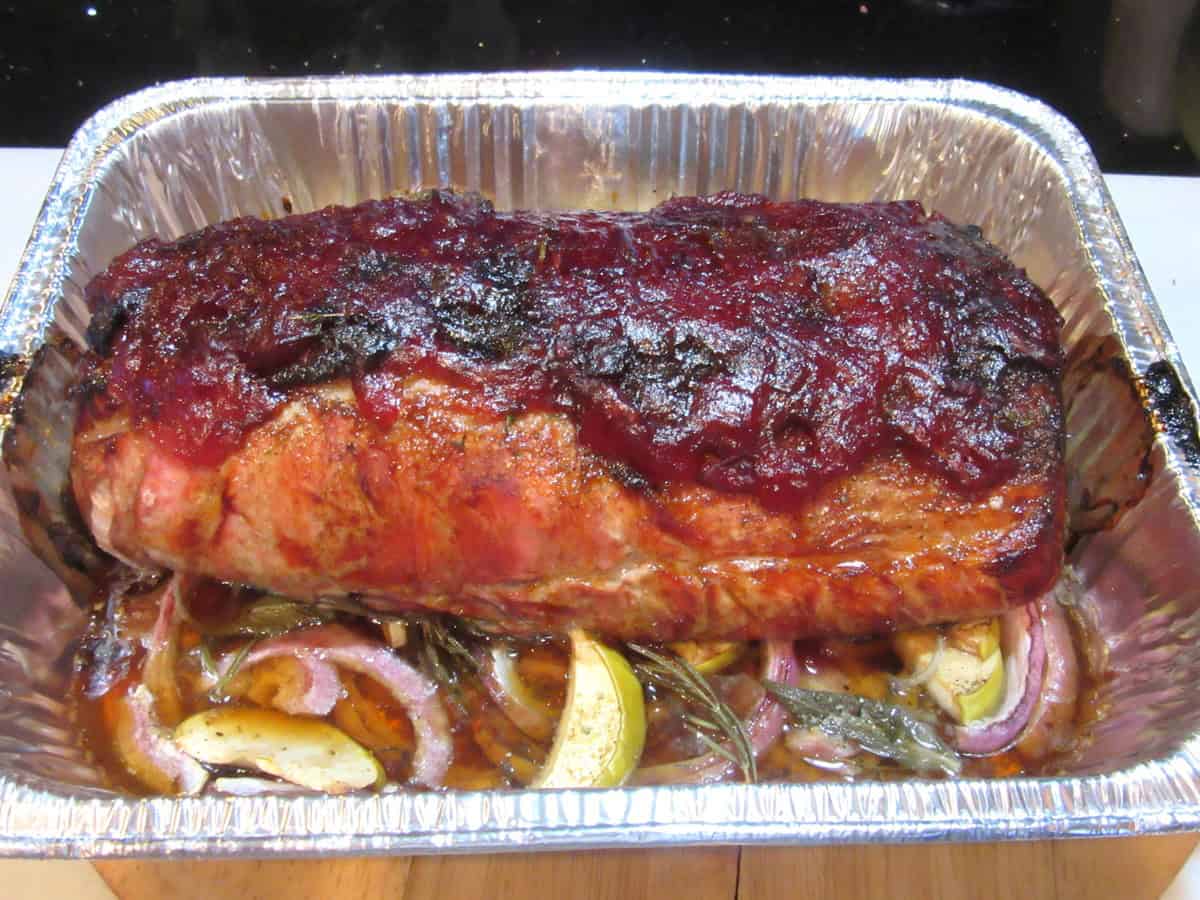 A golden brown pork roast topped with cranberry glaze.