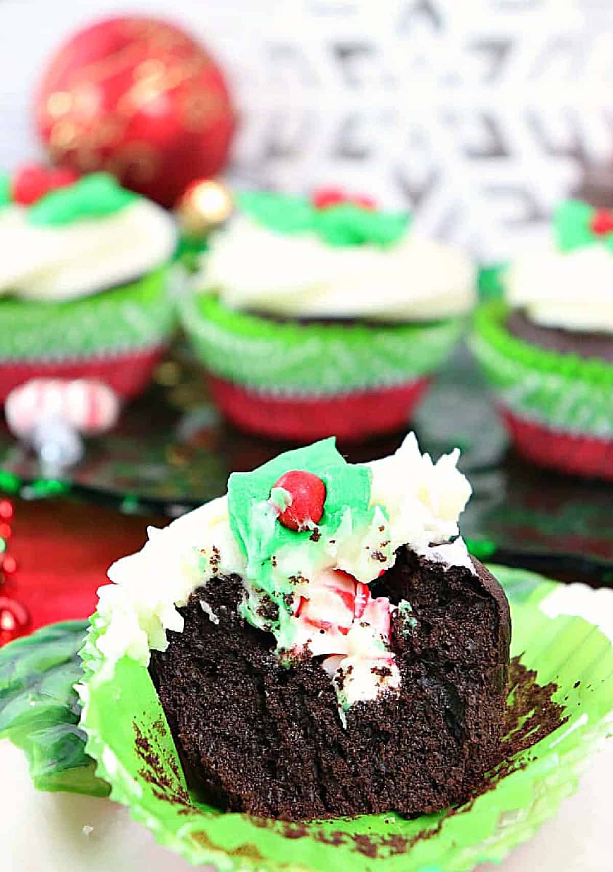 A chocolate cupcake filled with crushed peppermint candy with plenty of buttercream frosting on top.