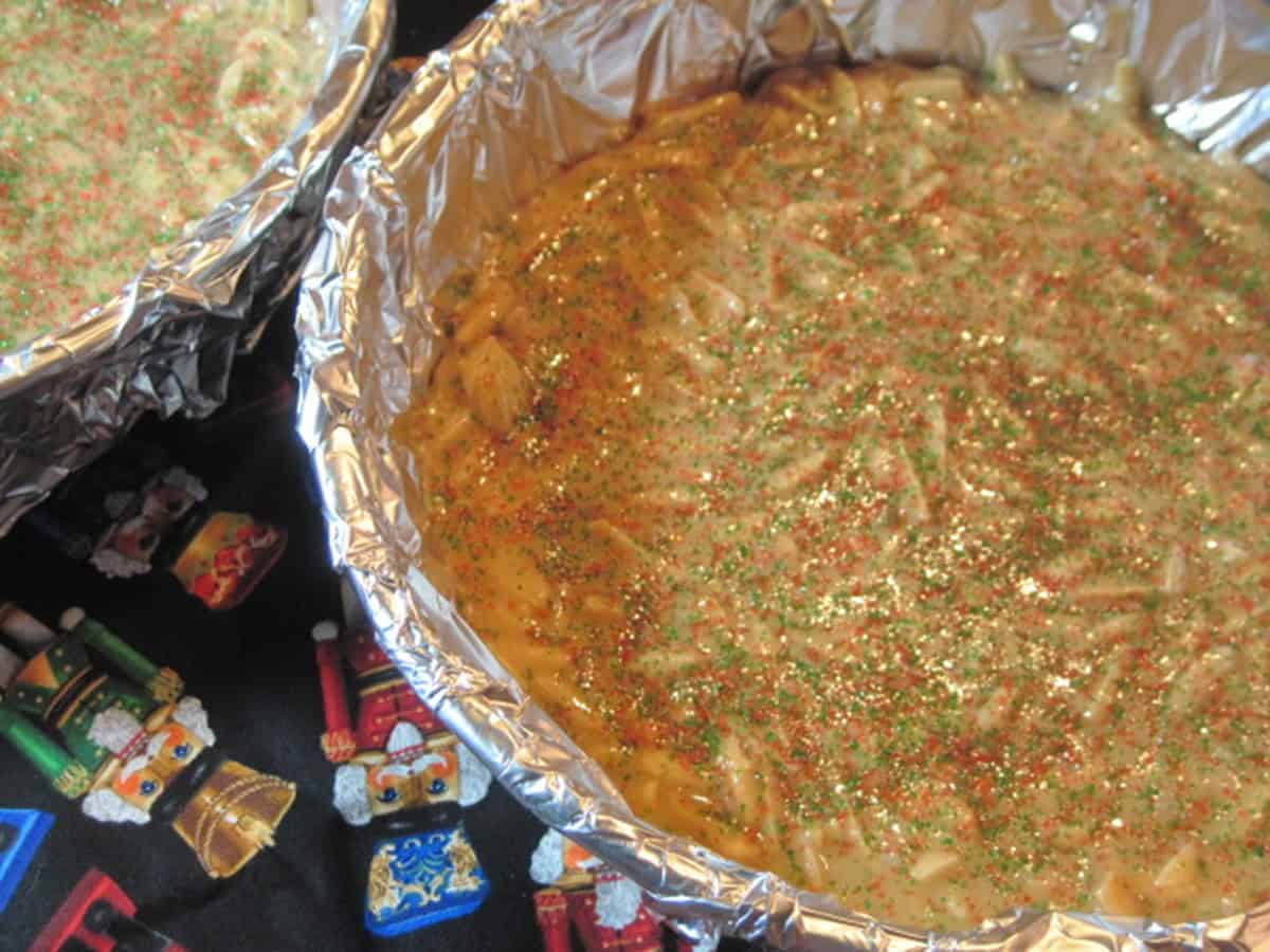 Two round discs of Almond Butter crunch in cake pans with aluminum foil.