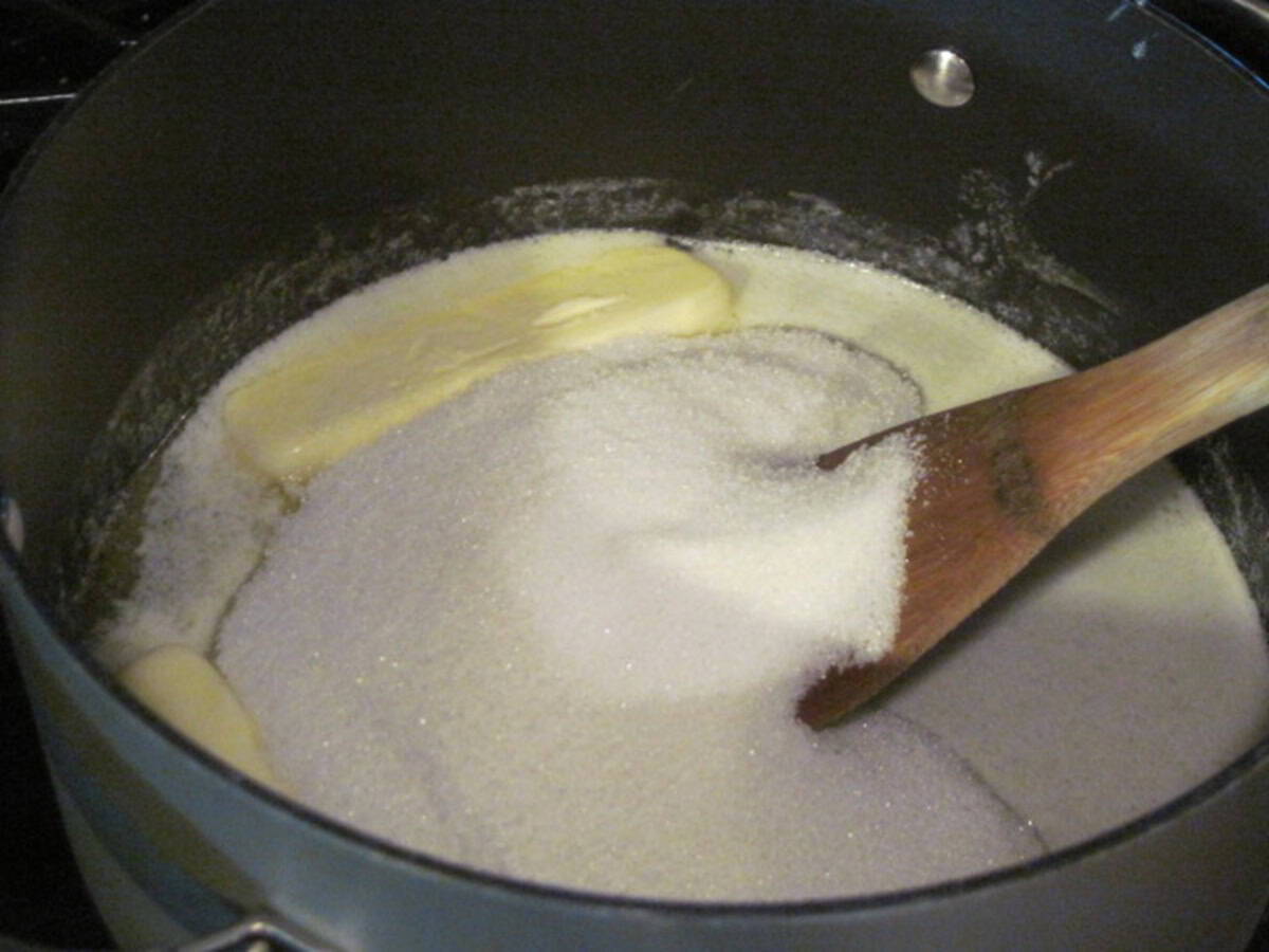 Granulated sugar and melted butter in a saucepan with a wooden spoon.