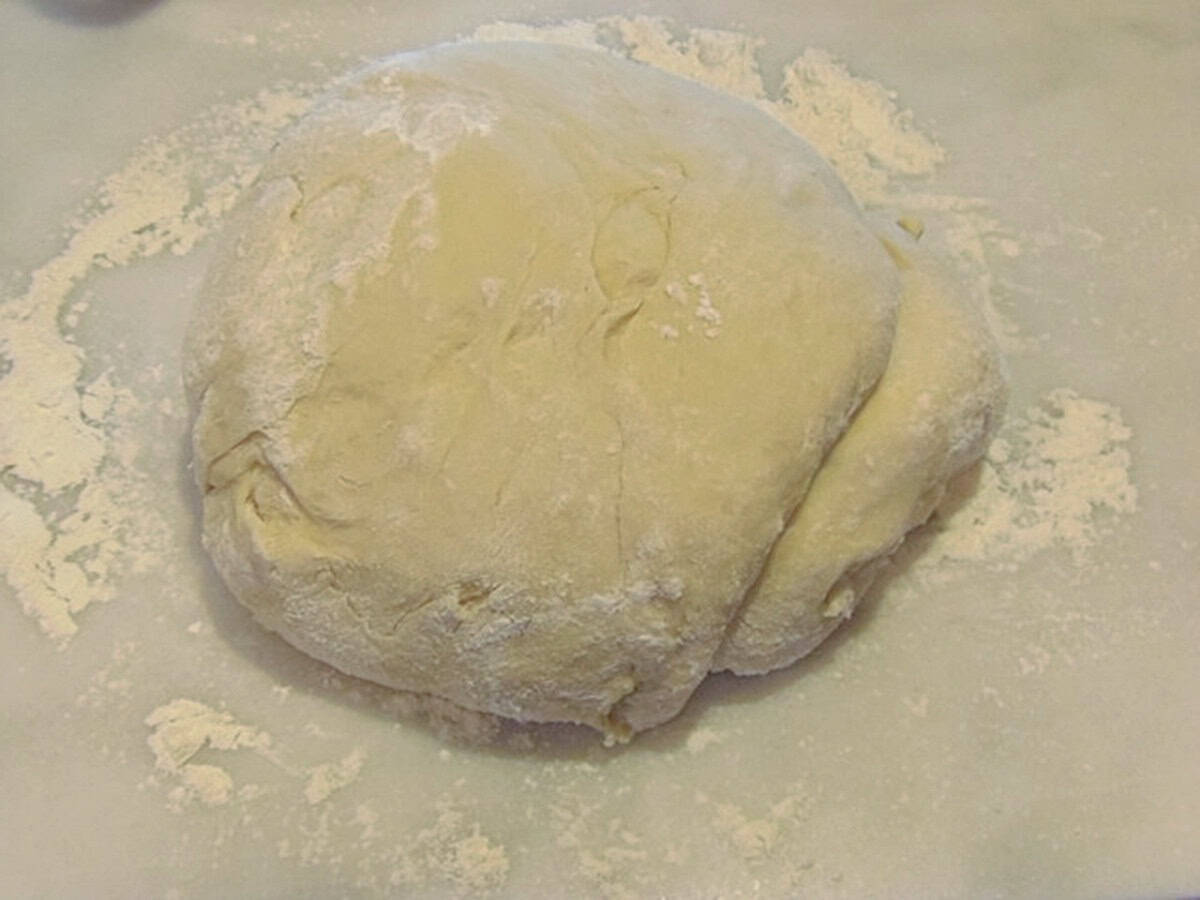 Mashed potato cinnamon roll dough on a floured surface.