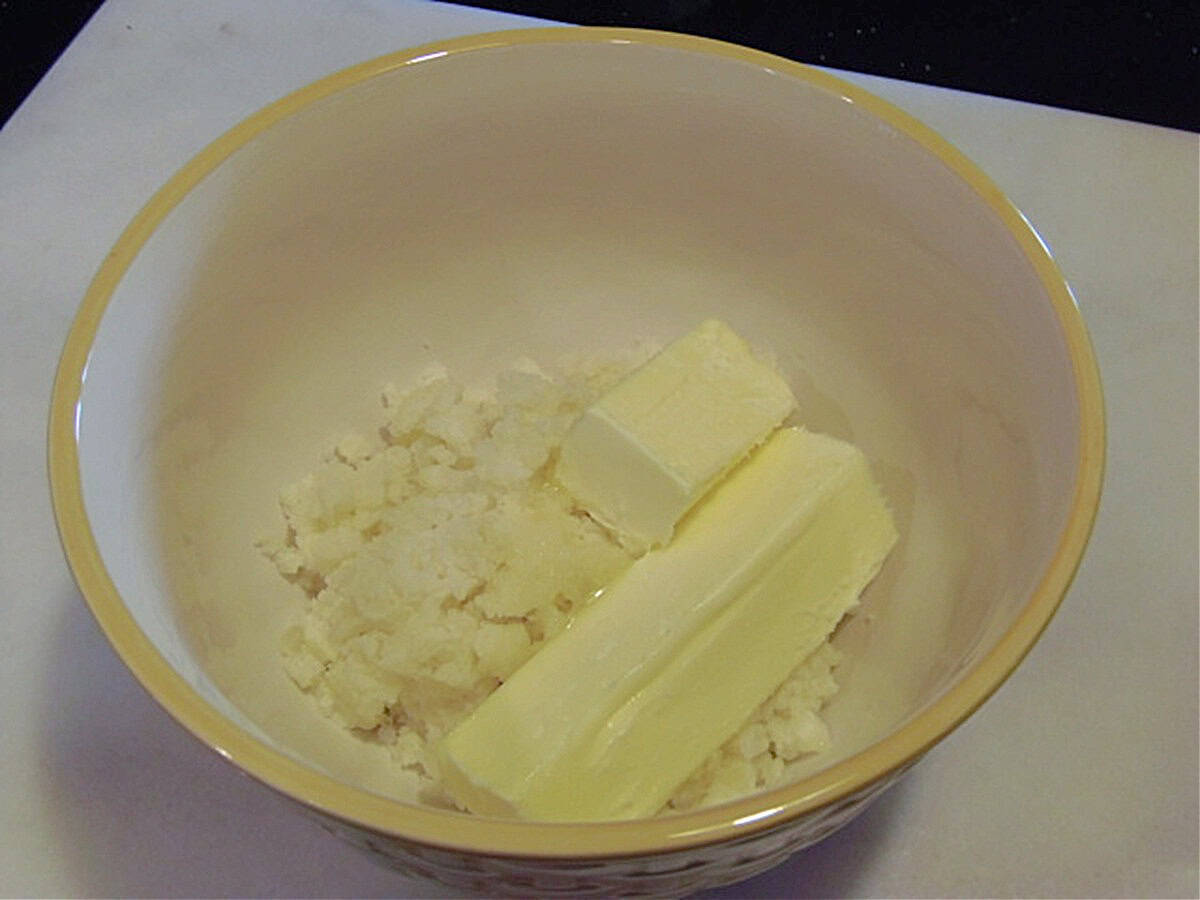 Dry mashed potatoes and butter in a bowl.