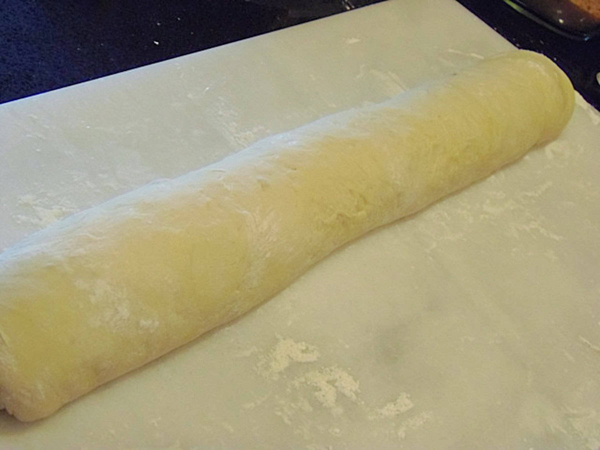 A long dough log for making cinnamon rolls before slicing.