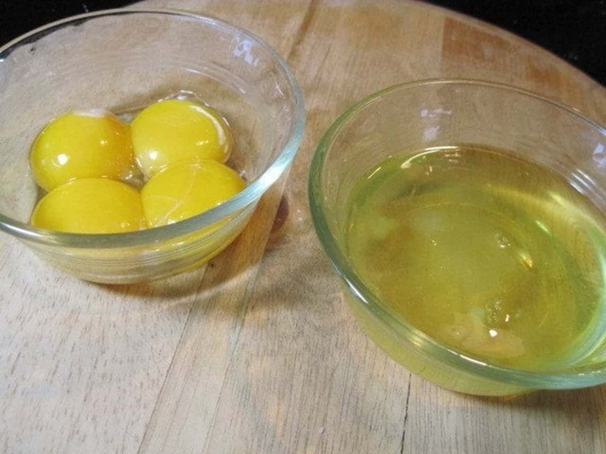Two small glass bowls; one with egg yolks and one with egg whites.
