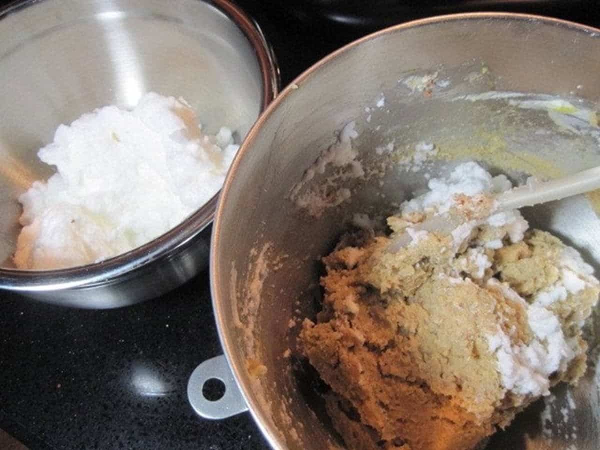 Beaten egg whites in one bowl and a cookie batter in a second bowl.