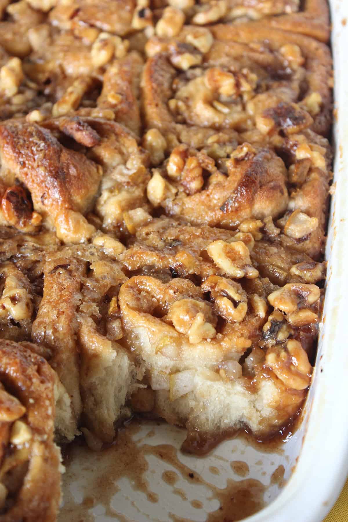 Pear and Walnut Sticky Buns Sticky buns in a baking pan with diced pears and walnuts.