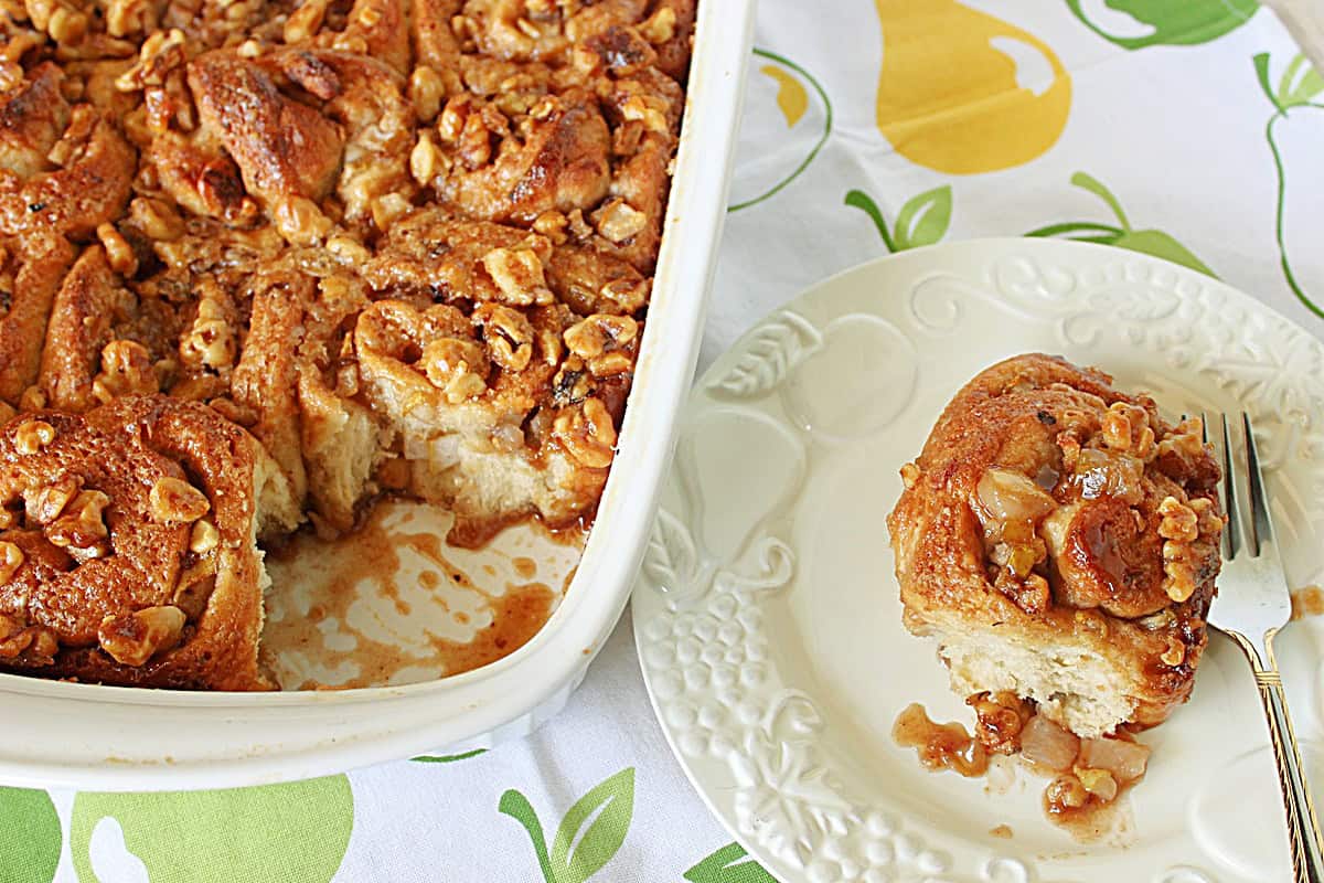 Pear and Walnut Sticky Buns An entire baking dish filled with pear and walnut sticky buns but one is out on a serving plate.