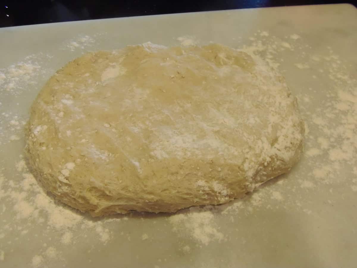 A risen slab of dough on a floured counter.