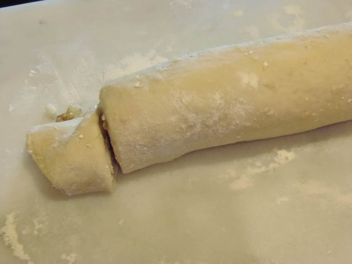 A roll of pear and walnut stick bun dough before being sliced for baking.