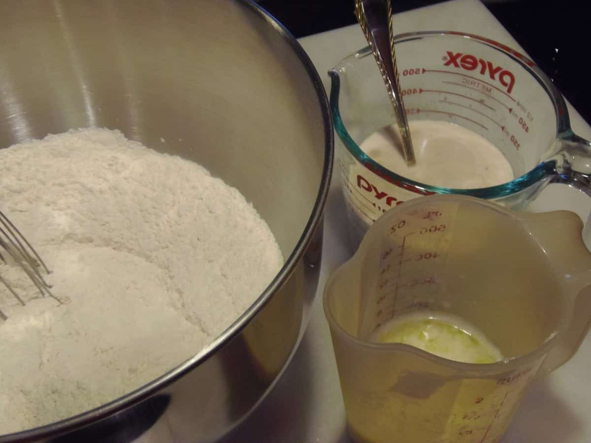 Three bowls on the counter, each holding a different ingredient for making sticky buns.