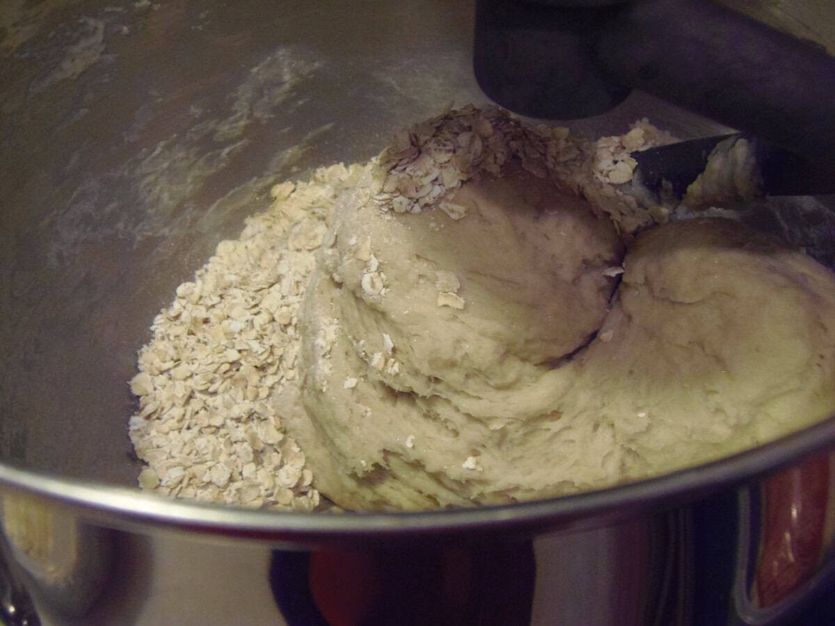 Oatmeal being kneaded into a soft dough in a stand mixer bowl.