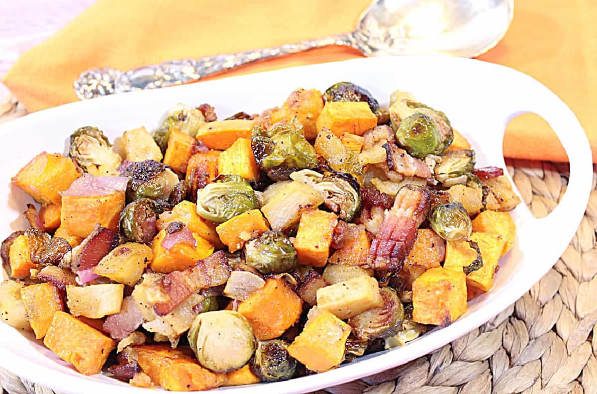 Sweet and Savory Roasted Sweet Potatoes, Brussels Sprouts and Apples - Kudos Kitchen by Renee Roasted orange sweet potatoes and green Brussels sprouts in a bowl with cooked bacon.