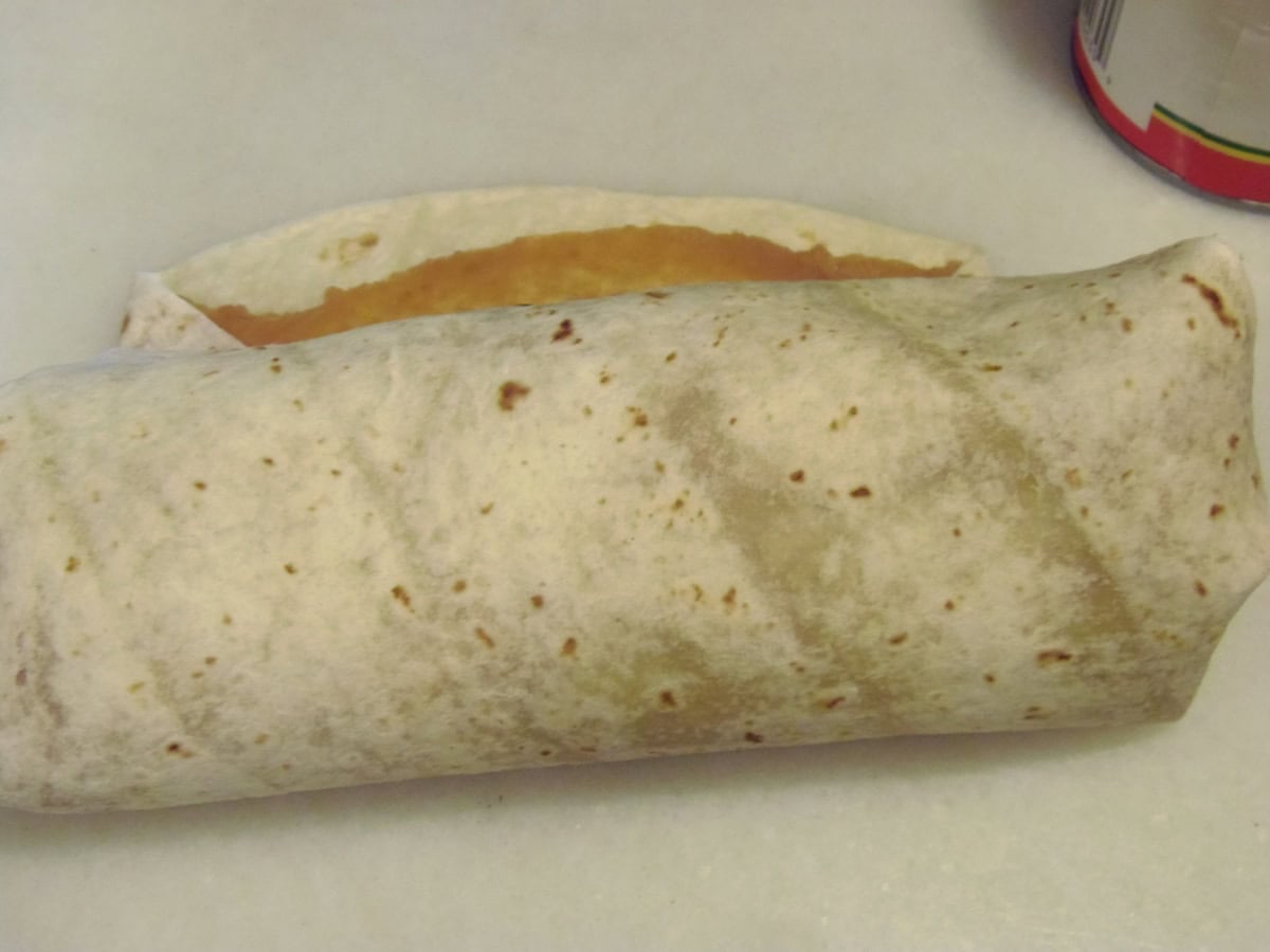 A flour tortilla wrapped around chicken and avocado filling.