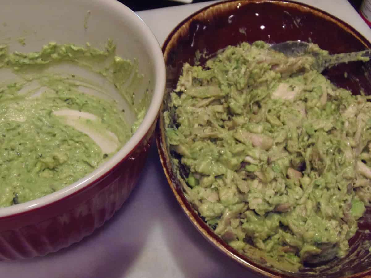 A bowl of mashed avocados next to a bowl of shredded chicken mixed with avocado.