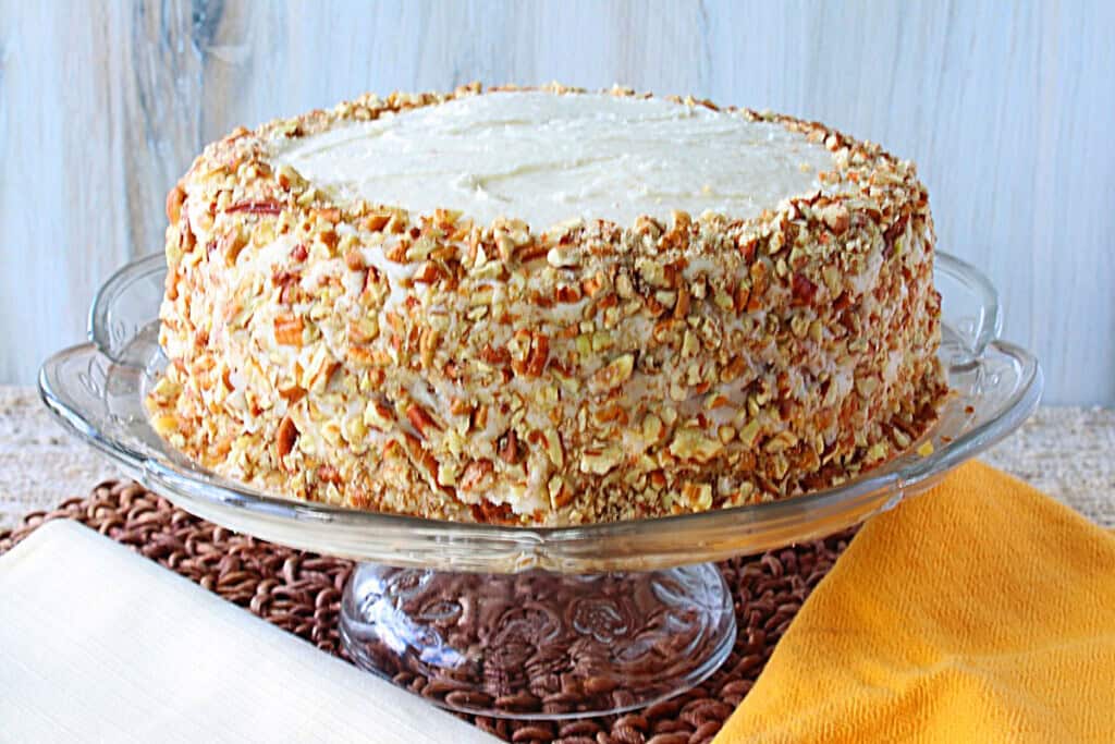 A banana layer cake on a glass cake stand.