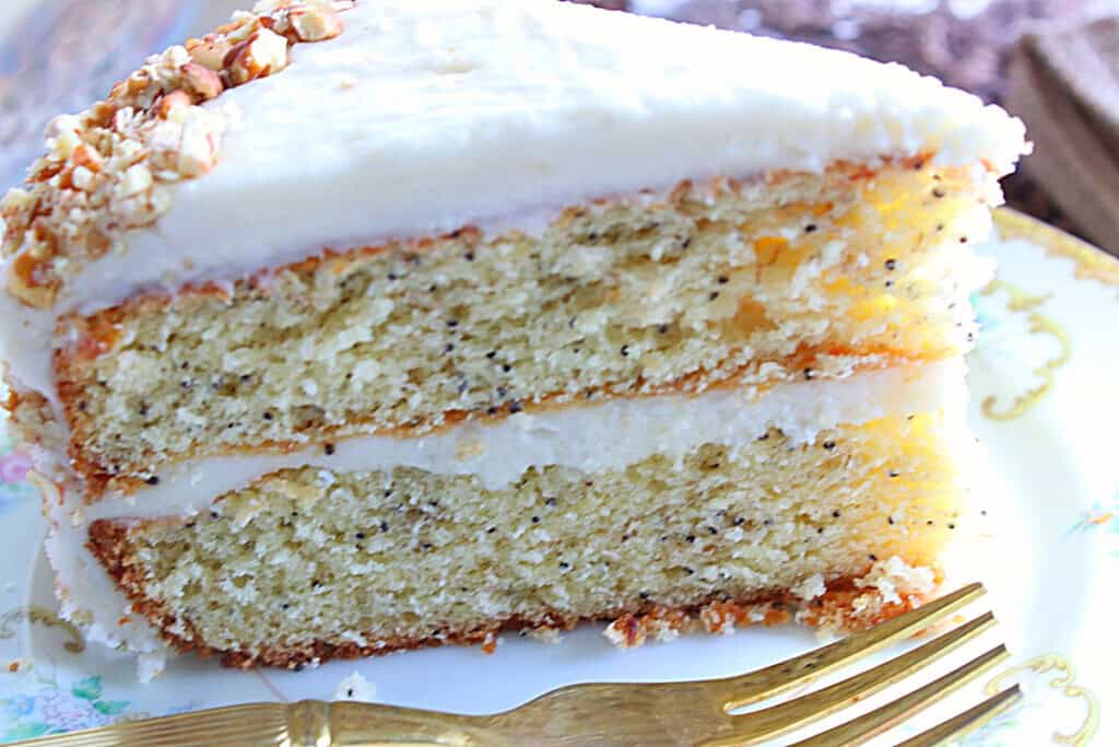 A slice of banana poppy seed layer cake with banana buttercream frosting on a plate.