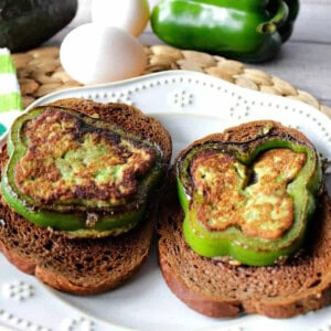 two slices of green pepper filled with avocado and grilled on slices of toast.