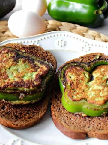 two slices of green pepper filled with avocado and grilled on slices of toast.