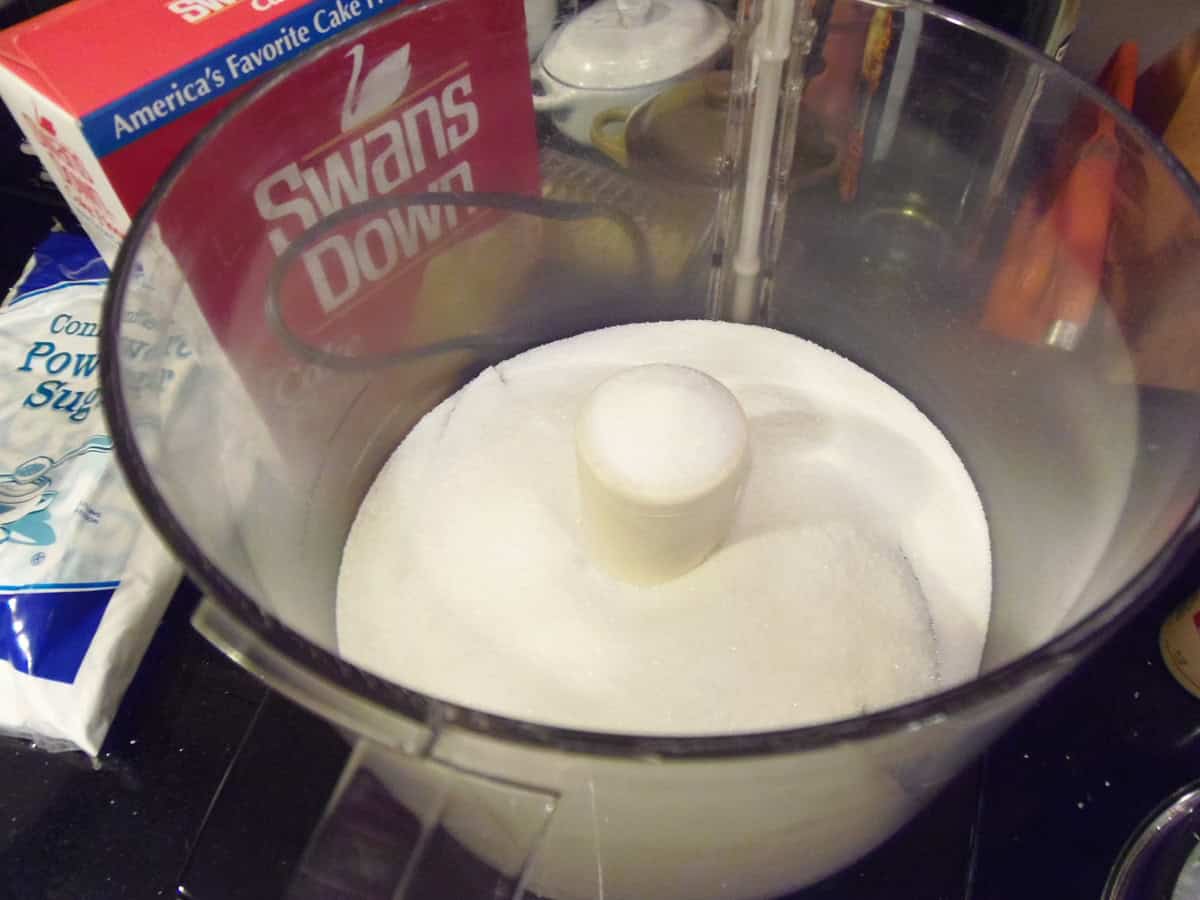 Granulated sugar in a food processor for making superfine sugar.