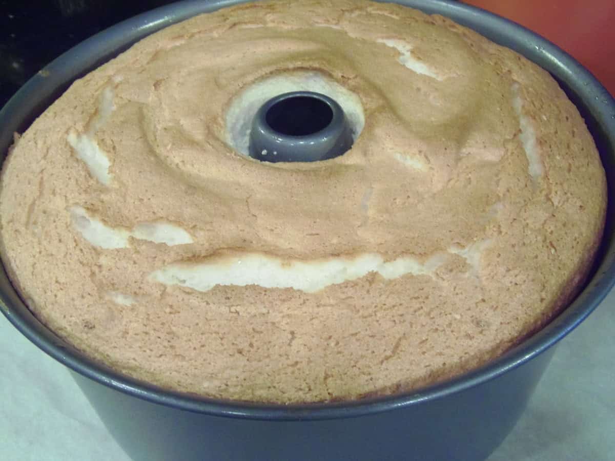 A golden, baked angel food cake in a cake pan.