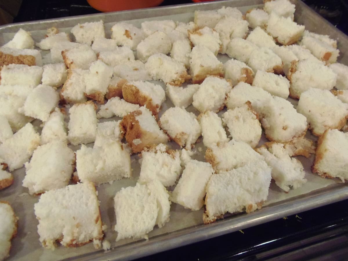 Cubed pieces of white angel food cake on a rimmed baking sheet.