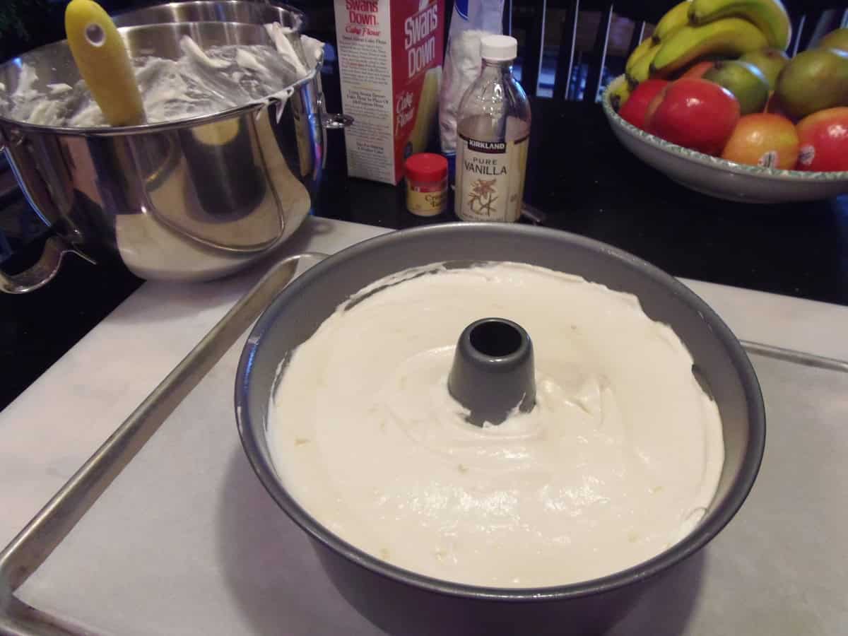 An unbaked angel food cake in a baking pan on a baking sheet.