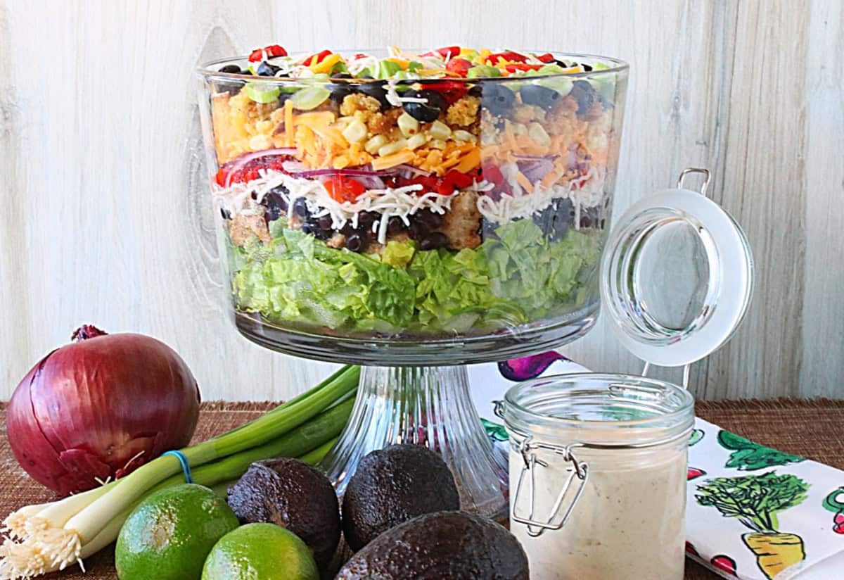 Layers upon layers of colors and textures of a beautiful salad in a glass bowl.