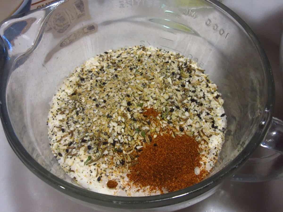 Potato flakes, everything seasoning, and smoked paprika in a glass mixing bowl.