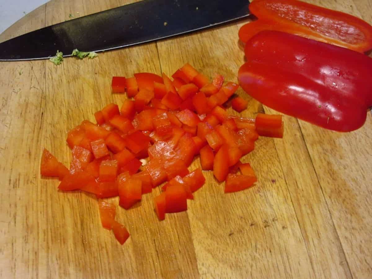 Diced red peppers on a cutting board.